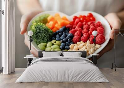 A heart-shaped plate filled with a vibrant assortment of fruits, vegetables, and nuts, symbolizing the love and care for health and nutrition on World Food Day. Wall mural