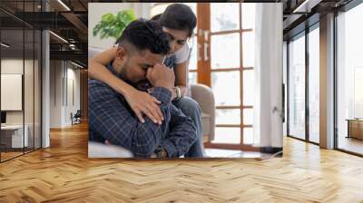 Indian couple sitting together indoors in the home house, calculating finances at home, looking seriously in documents bills payment online Wall mural