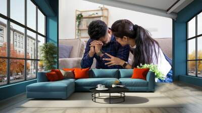 Indian young cuople stress relief trust talk share disappointment suffer serius pain sick sorrow cry man and wife encourage him at sofa Wall mural