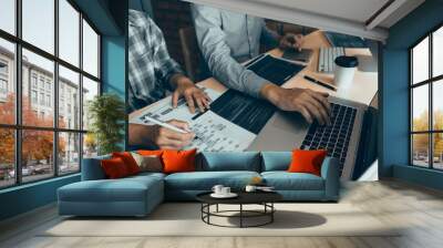 Two software developers are using computers to work together with their partner at the office desk. Wall mural