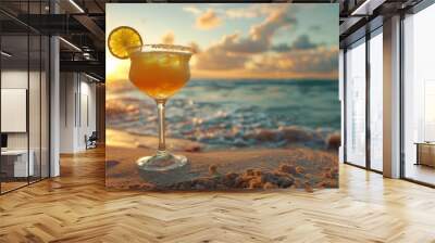 A refreshing cocktail sits on the beach with a sunset in the background. Wall mural