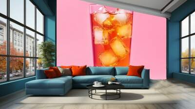 A clear glass with a pink background and an iced tea with ice Wall mural