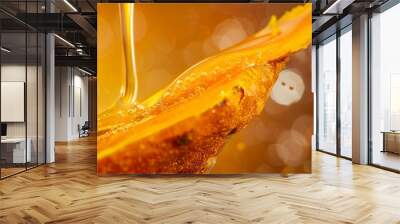 A modern and clean close-up photograph of a turmeric cross-section with honey flowing over it, set against a luxurious wine-colored background. The orange hue of the turmeric is emphasized Wall mural