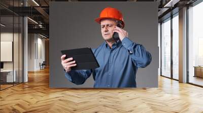 Engineer with tablet and mobile phone Wall mural