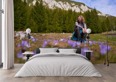 Woman hiker in a field of crocus flowers Wall mural