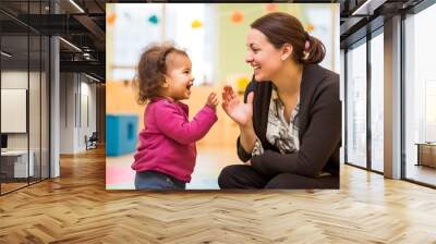 A dedicated assistante maternelle teaching sign language to infants and toddlers for better communication. Wall mural