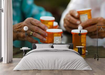 Senior couple taking their medication together managing health care routines with prescription bottles visible. Wall mural