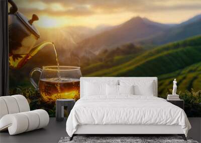 Tea pouring from teapot into glass cup, tea plantation background, copy space Wall mural