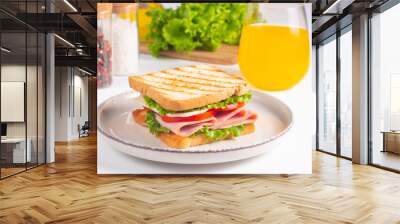 Close-up of two sandwiches with bacon, salami, prosciutto and fresh vegetables on rustic wooden cutting board. Club sandwich concept Wall mural