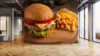 Home made hamburger with beef, onion, tomato, lettuce and cheese. Fresh burger close up on wooden rustic table with potato fries, beer and chips. Cheeseburger. Wall mural