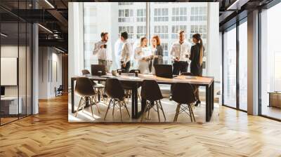 A team of young businessmen working and communicating together in an office. Corporate businessteam and manager in a meeting. desktop against the background of the pan window, free space for text Wall mural