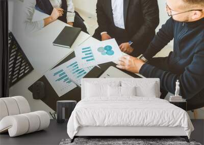 A team of young businessmen working and communicating together in an office. Corporate businessteam and manager in a meeting. Wall mural