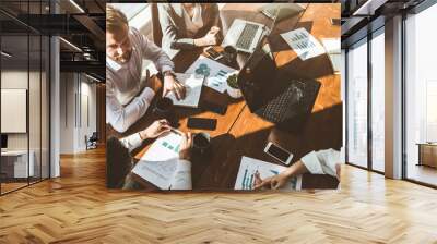 A team of young businessmen working and communicating together in an office. Corporate businessteam and manager in a meeting. Wall mural