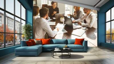 A team of young businessmen working and communicating together in an office. Corporate businessteam and manager in a meeting. Wall mural