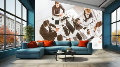 A team of young businessmen working and communicating together in an office. Corporate businessteam and manager in a meeting. Wall mural