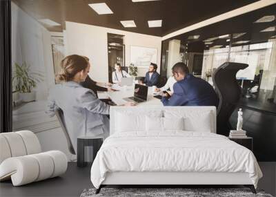 A team of young businessmen working and communicating together in an office. Corporate businessteam and manager in a meeting Wall mural