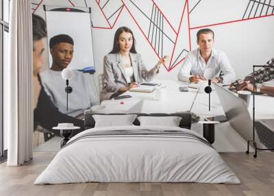 A team of young office workers, businessmen with laptop working at the table, communicating together in an office. Corporate businessteam and manager in a meeting. coworking. Wall mural