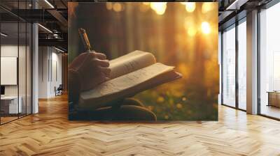 A woman is sitting in a forest and writing in a book Wall mural