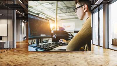 Engineer designer working on desktop computer in factory Wall mural