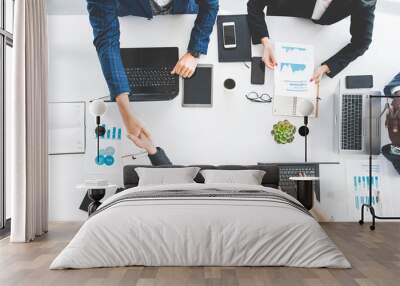 Group of young business people working and communicating while sitting at the office desk together with colleagues sitting. business meeting. Desktop top view. Wall mural