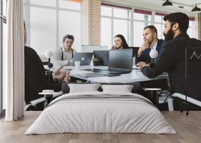 Group of young business people working and communicating while sitting at the office desk together with colleagues sitting. business meeting Wall mural