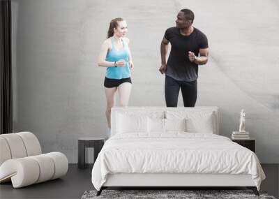 happy young couple afro-american man and european woman running together. A loving couple is run, engaged in sports, family values Wall mural