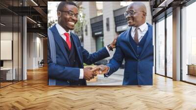 Meeting of two long-time friends of black African American businessman in suits outdoors Wall mural