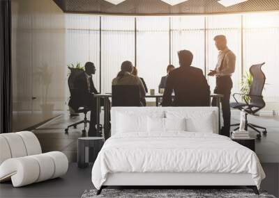 Silhouettes of people sitting at the table. A team of young businessmen working and communicating together in an office. Corporate businessteam and manager in a meeting Wall mural