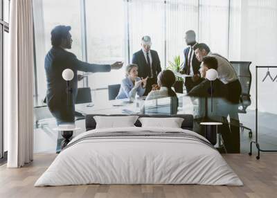 Silhouettes of people sitting at the table. A team of young businessmen working and communicating together in an office. Corporate businessteam and manager in a meeting Wall mural