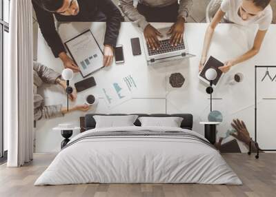 top view work workplace. A team of young office workers, businessmen with laptop working at the table, communicating together in an office. Corporate businessteam and manager in a meeting. coworking. Wall mural