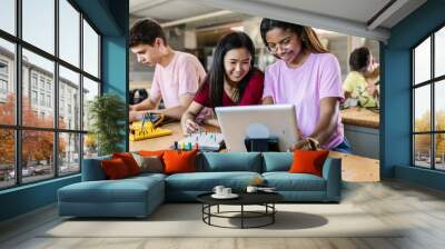 Group of diverse teenage students learning together to build electronic circuits at high school - Asian and african american female classmate working at technology class Wall mural