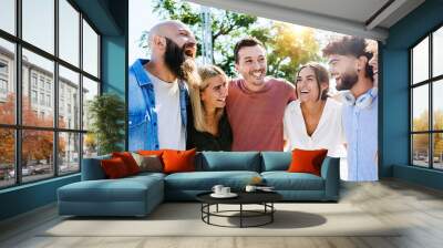 Group of smiling young friends having fun together outdoors - Multiracial millennial people laughing while hanging out in city street on summer vacation - Friendship and unity concept Wall mural