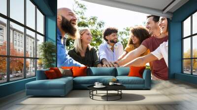 Group of united multiracial people stacking hands together - Cooperation, collaboration, community and unity concept with multiethnic young college students celebrating together on campus university Wall mural