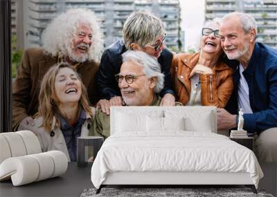 Happy group of senior people laughing while sitting together outdoors. Elderly mature people Wall mural