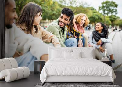 Happy group of trendy young people laughing sitting in city street. Millennial diverse student friends having fun together outdoor Wall mural