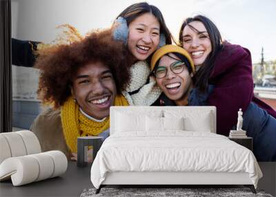 Happy multiracial young friends standing together outdoor smiling at camera. International friendship concept with group of four millennial people from diverse cultures having fun together Wall mural