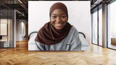 Portrait of young happy african black woman in muslim headscarf at home. Proud of religion and islamic people concept Wall mural