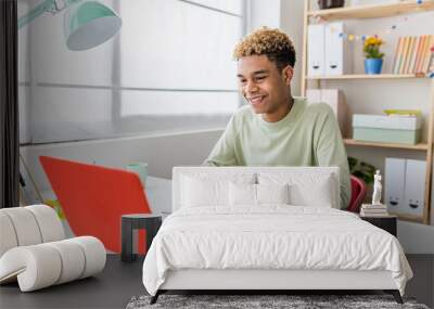 Smiling teenager boy studying online from home having a video conference on laptop with school teacher - Education and learning online concept Wall mural