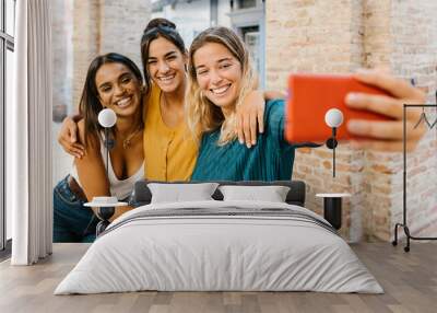 Three multiracial young friends having fun taking self portrait with cell phone on summer vacation in Italy - Cheerful teenager girls laughing together enjoying summer holidays Wall mural