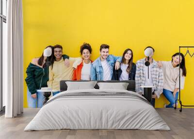 Young adult united group of multiracial happy friends leaning on yellow wall - Community and unity concept with diverse trendy teenage people smiling at camera Wall mural