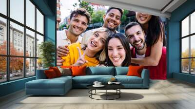 Young group of people having fun enjoying free time together taking selfie portrait at city street. Millennial student friends laughing outdoors. Youth community concept. Wall mural