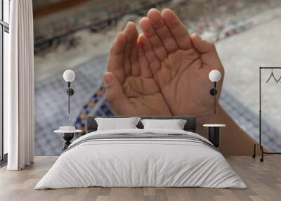 A person's hands are shown in front of a carpet with the words  prayer  on it. Wall mural