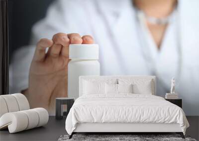 female doctor holding and showing a medicine bottle Wall mural