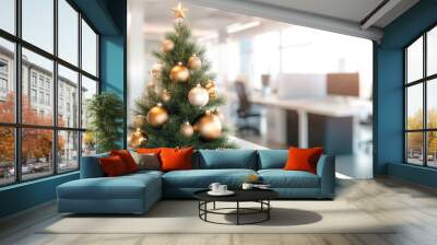 A Christmas tree with golden and silver ornaments sits on a table in a modern office interior, with a blurred background of desks and computer workstations. Christmas concept for business copy space  Wall mural