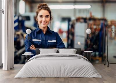 Smiling young  car mechanic woman posing with arm crossed  in auto repair shop, mechanic woman happy working in car garage,  Wall mural