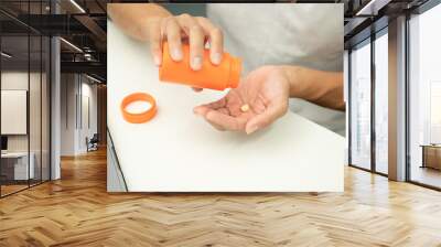 person putting pills  on their hands Wall mural