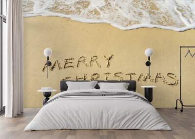 Merry Christmas handwritten in sand on beach Wall mural