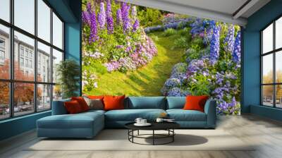 path leading through a flower garden with delphinium high inflorescences violet flowers. Wall mural