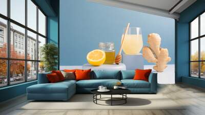 Antioxidant drink fresh ginger lemon honey glass trendy blue background, podium minimalism, balance Wall mural