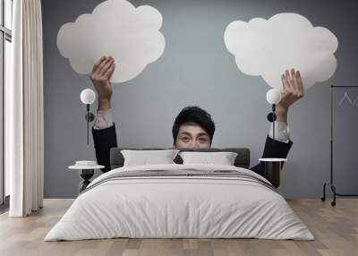 businessman holding two paper clouds, studio shot Wall mural